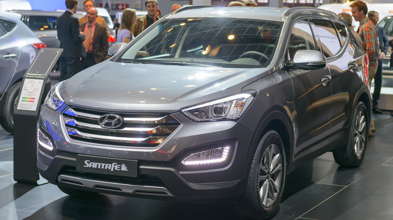 A gray 2015 Hyundai Santa Fe on a showroom floor