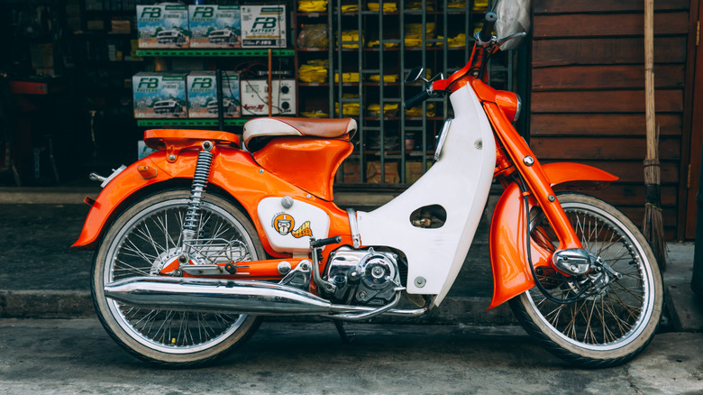 Honda Super Cub parked outside shopfront