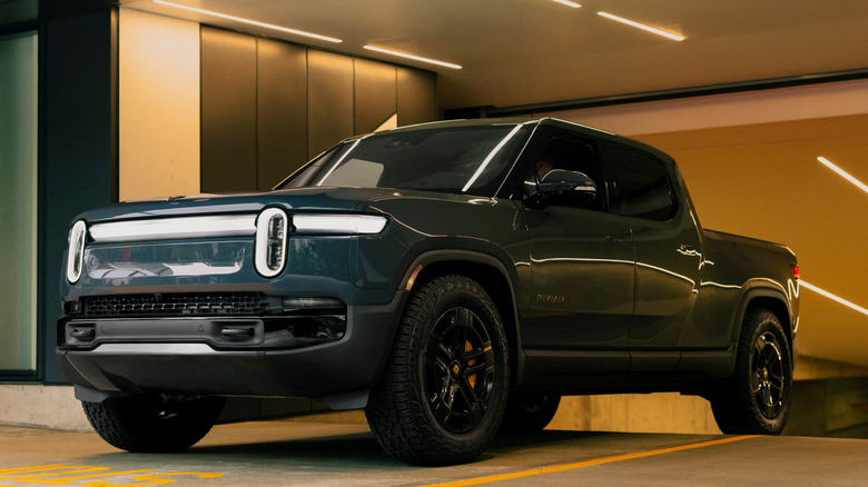 Dark green Rivian R1T exiting parking garage