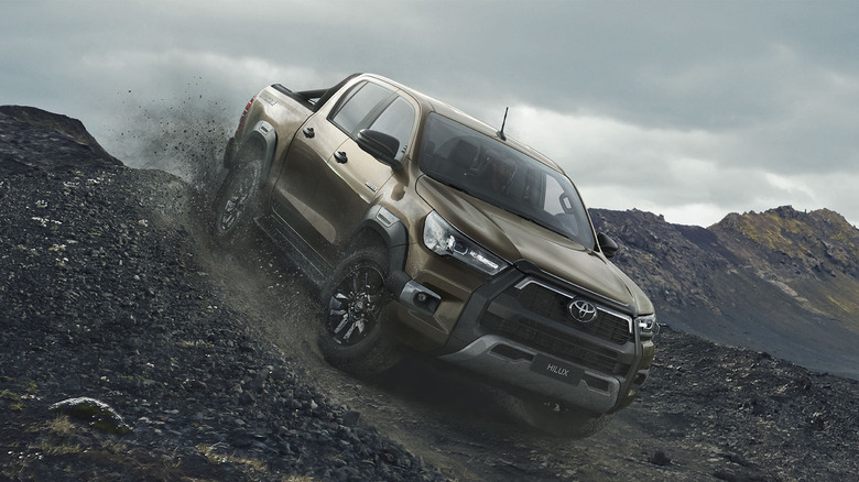 2024 Toyota Hilux driving down a slope in off-road conditions