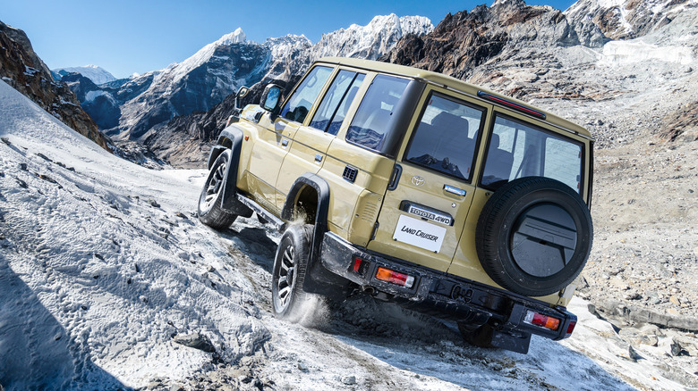 2024 Toyota Land Cruiser 70 Series driving on an incline on rocky surface