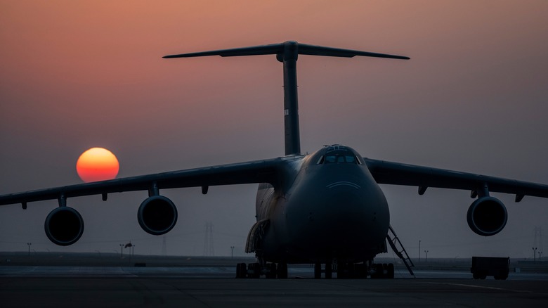 The sun rises behind a U.S. Air Force C-5M Super Galaxy