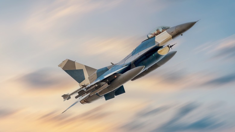 Heavily armed military F-16 Fighting Falcon on a combat mission against a dramatic sky