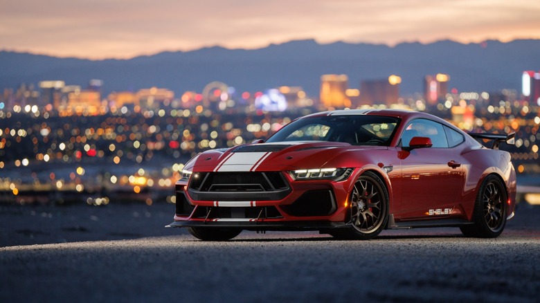 Red and white Shelby Super Snake parked on dirt