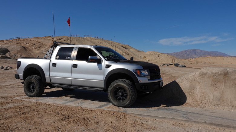 The Ford F-150 SVT Raptor in silver in the desert, side view 