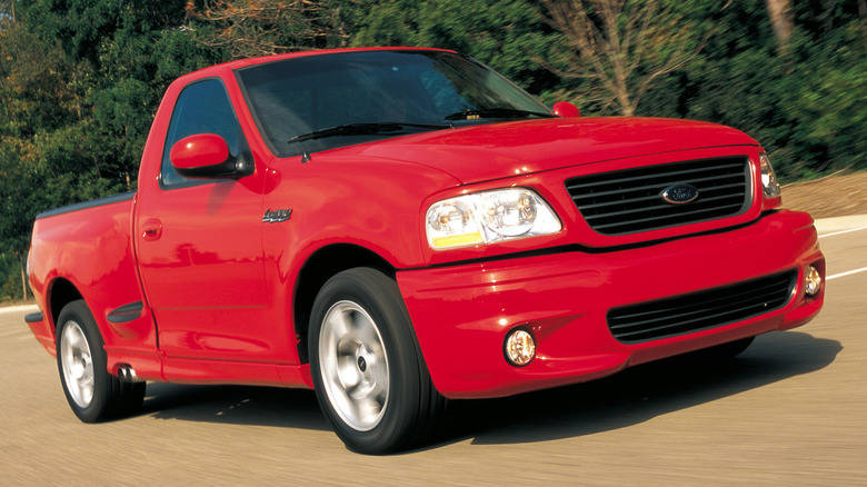 The Ford F-150 SVT Lightning in red, front 3/4 view, driving