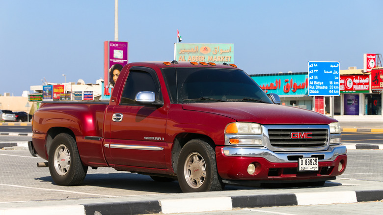 A GMT800 GMC Sierra in red, single cab, front 3/4 view