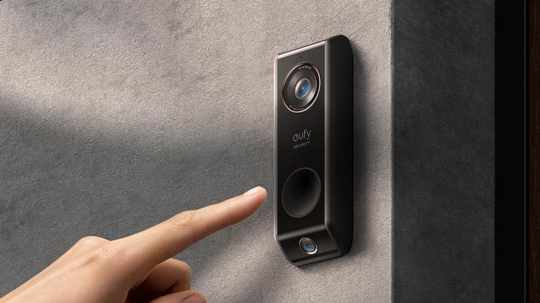 A person preparing to press a video doorbell button