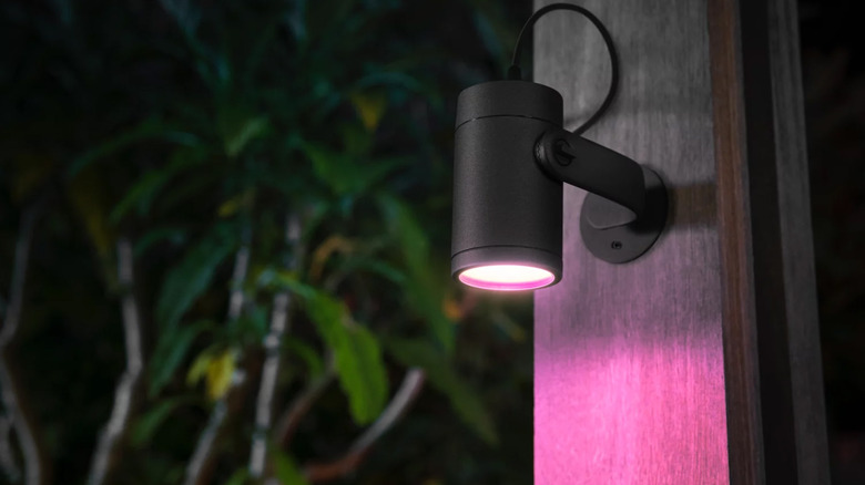 A Philips Hue spotlight mounted on a wood beam outside