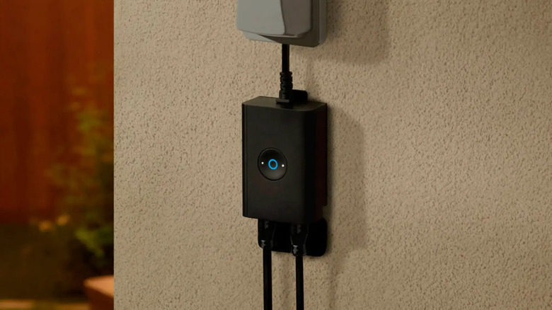 A Ring outdoor smart plug on an exterior house wall