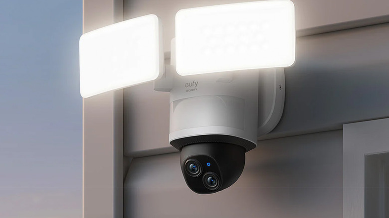 A Eufy smart floodlight and camera hanging on a house