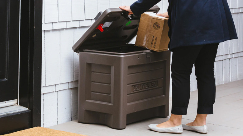 A person opening a smart delivery box to retrieve packages