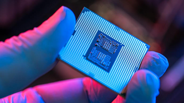 A gloved hand putting a CPU on a motherboard