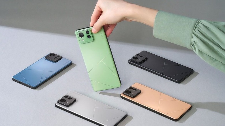 Hand picking up a green ASUS Zenfone