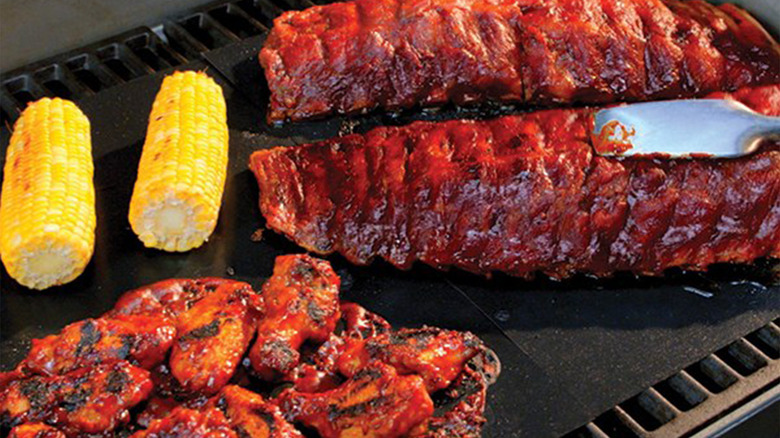 Various grill food items on top of a black mat