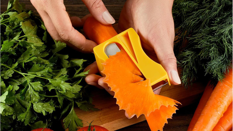 A person peeling a carrot in a pencil sharpener