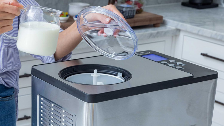 A person pouring cream into an ice cream maker