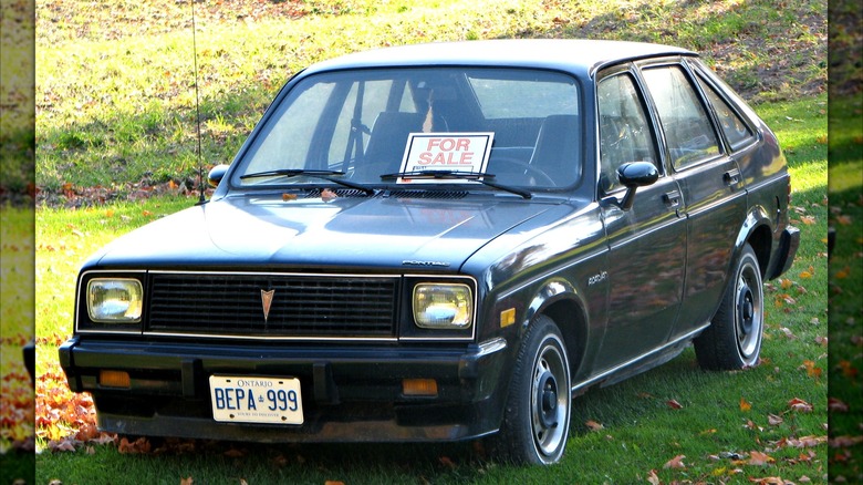 Black Pontiac Acadian parked on grass