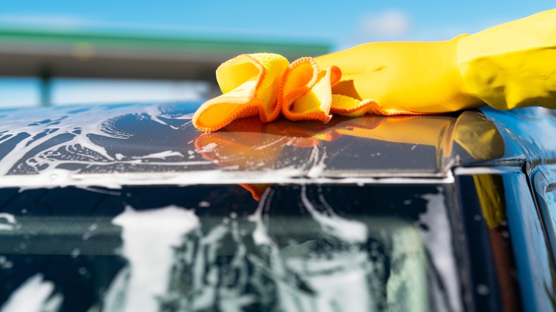 Driver using microfiber towel to clean roof