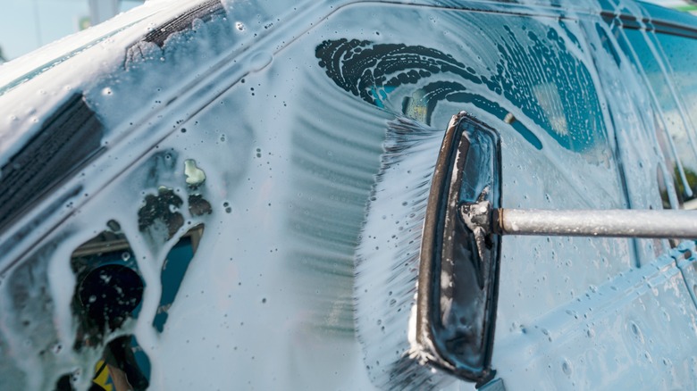 Person washing car with pH-balanced soap