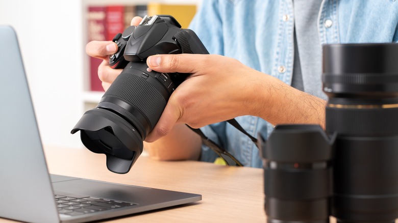 A DSLR Camera held near macbook