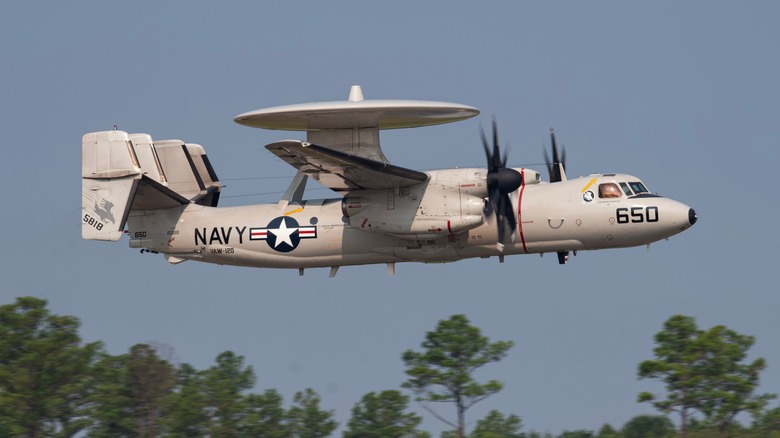 E-2 Hawkeye flying naval shipping operations in the Red Sea over trees