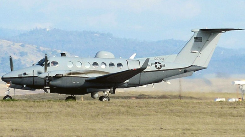 MC-12W Liberty on the ground surrounded by grassy fields