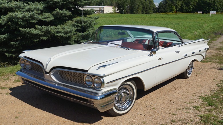 White 1959 Pontiac Bonneville parked on dirt