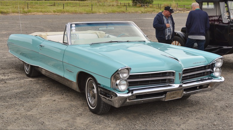 Teal 1965 Pontiac Bonneville Convertible parked on dirt