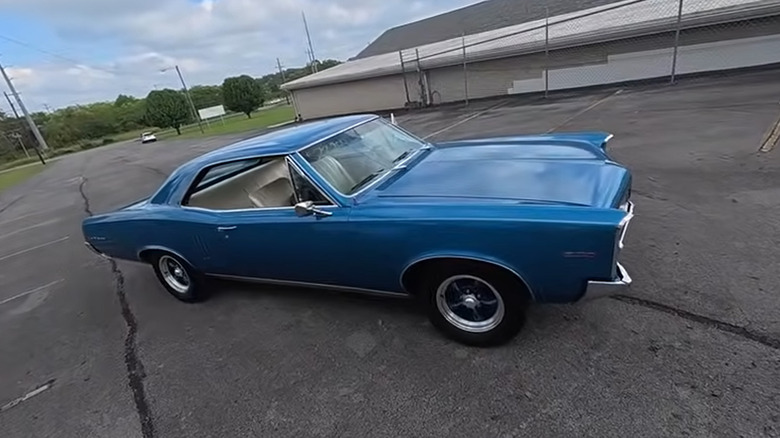 A blue Pontiac LeMans in a parking lot