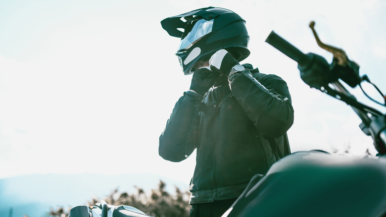 Person putting on a motorcycle helmet