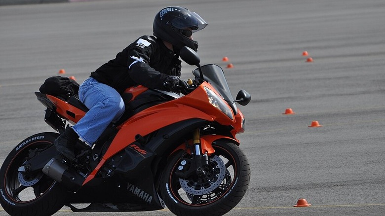 Person riding a motorcycle on a course with cones