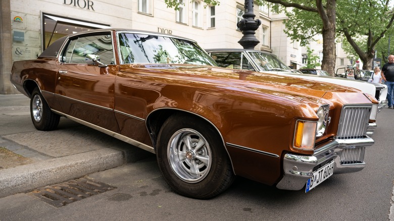 Bronze 1971 Pontiac Grand Prix parked on sidewalk