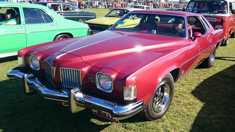 Red 1973 Pontiac Grand Prix parked on grass