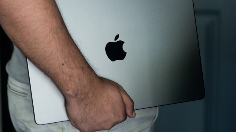 man holding macbook