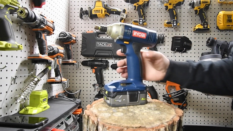 An old blue Ryobi drill on a tree stump