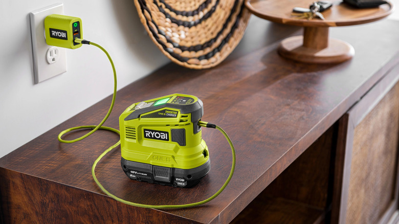 Ryobi charging device on a wood table plugged into a wall