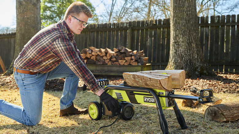 Man using a tool to split firewood