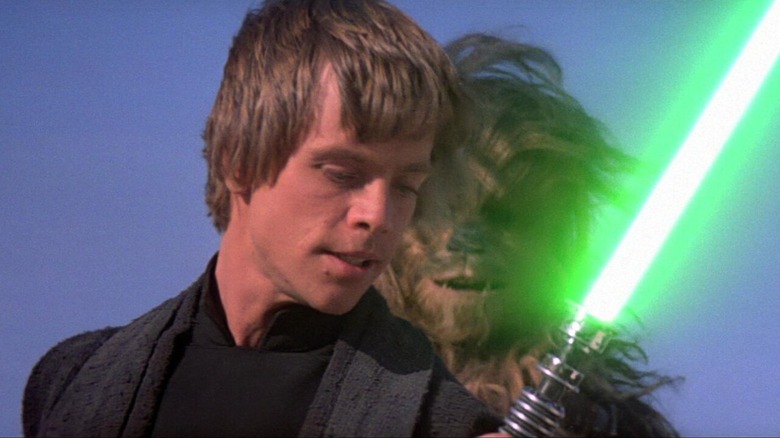 Luke Skywalker holding green lightsaber chewbacca