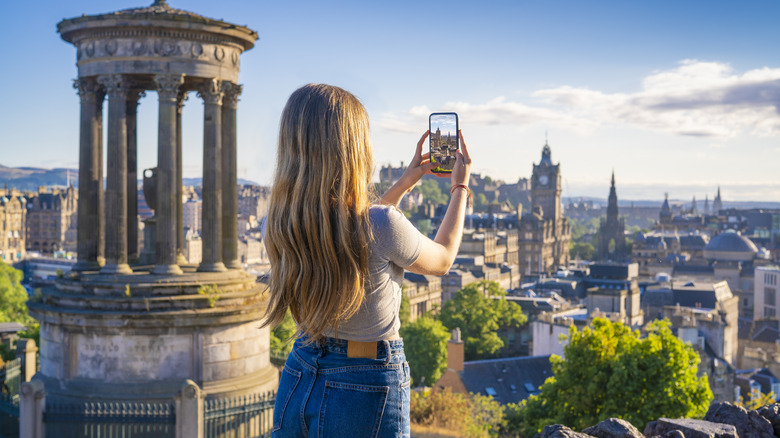 young woman taking photo Edinburgh smartphone
