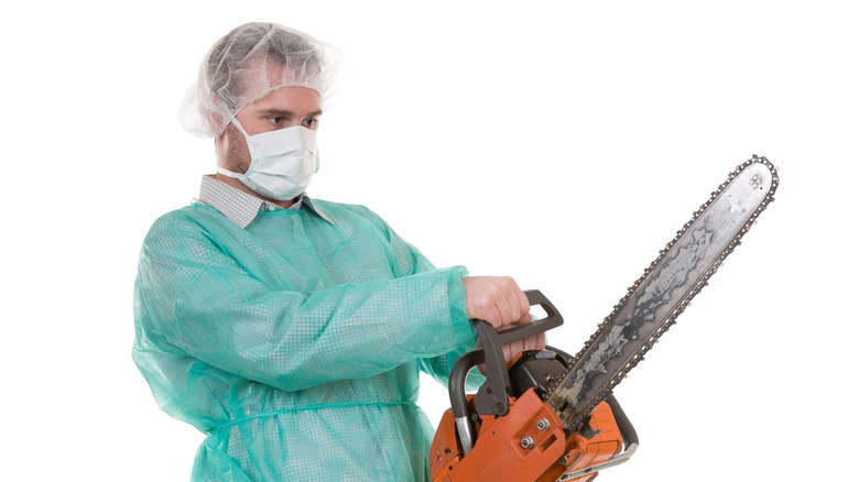 surgeon wearing mask fuel-powered chainsaw