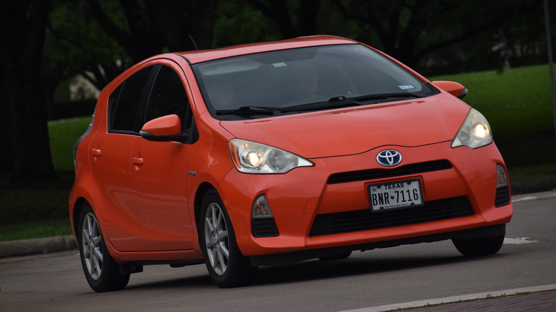 Orange Toyota Prius cruising down road