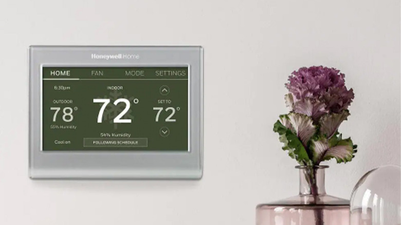 A Honeywell Wi-Fi Smart Color Thermostat on a gray wall