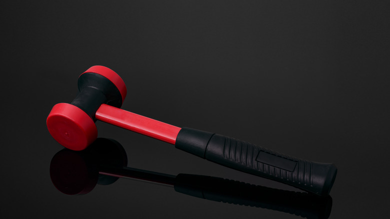 a red and black dead blow hammer