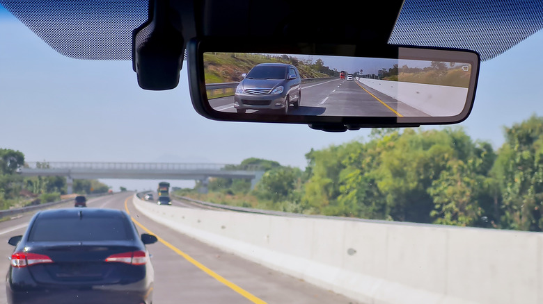 View of a car's rearview mirror while driving on a highway