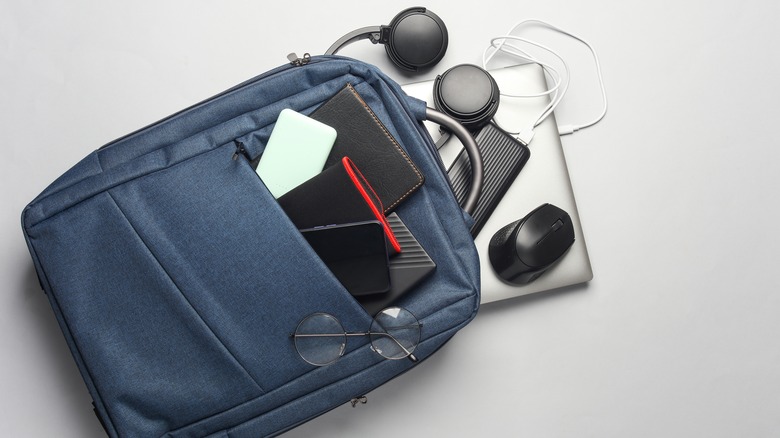 A backpack bursting with travel electronics