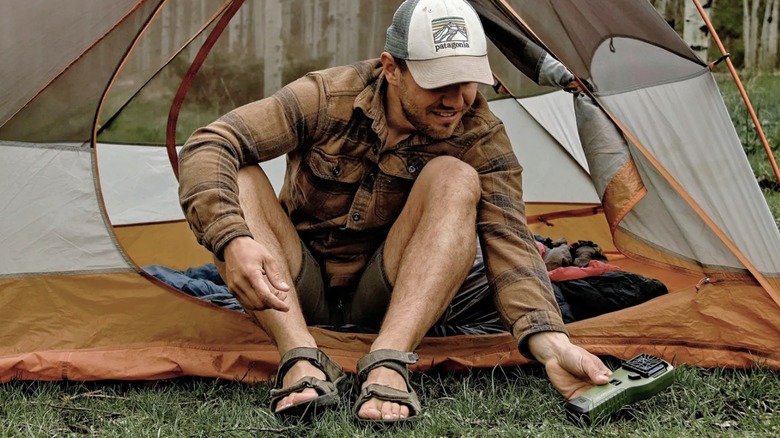 A hiker sets the Thermacell Portable Mosquito Repeller to protect his tent.