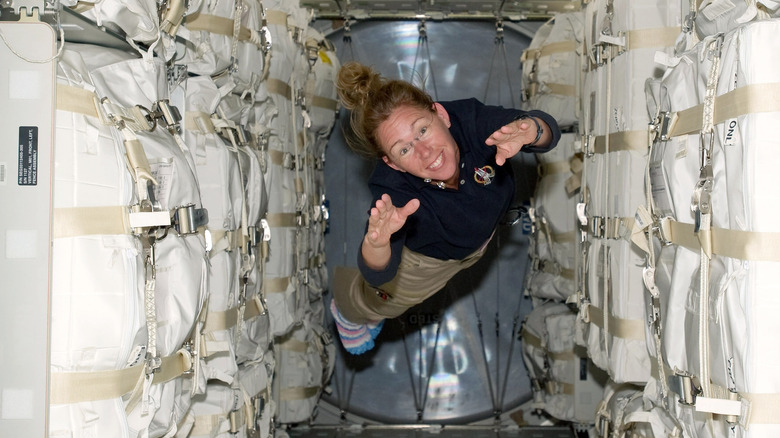 Astronaut floating through capsule