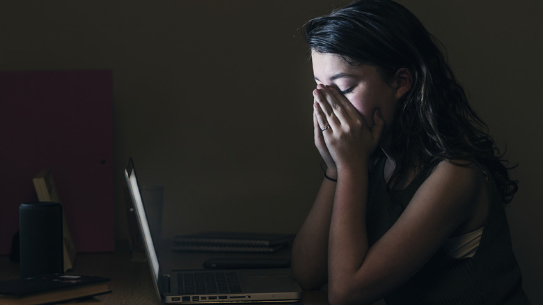 Upset woman in front of computer