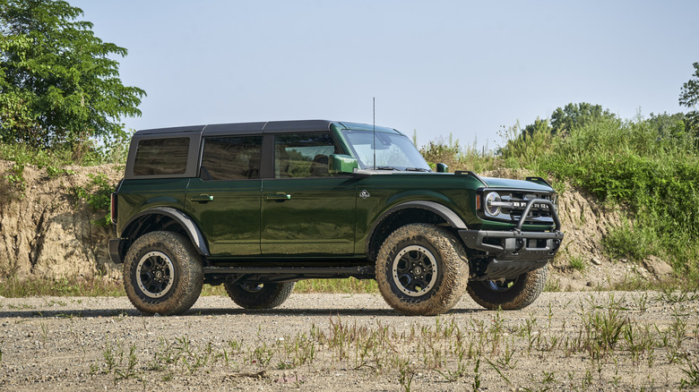 2022 Ford Bronco in Eruption Green parked on gravel with vegetation backdrop